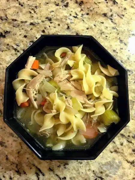 Slow cooker noodle soup in a black bowl