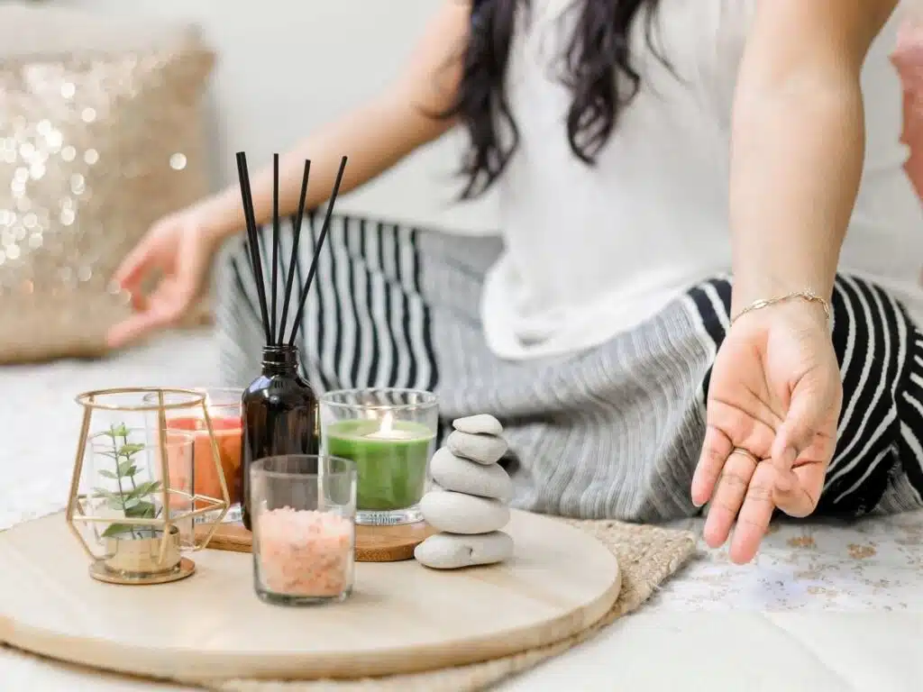 woman meditating with incense and candle