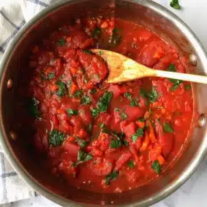 Pasta sauce topped with chopped parsley.