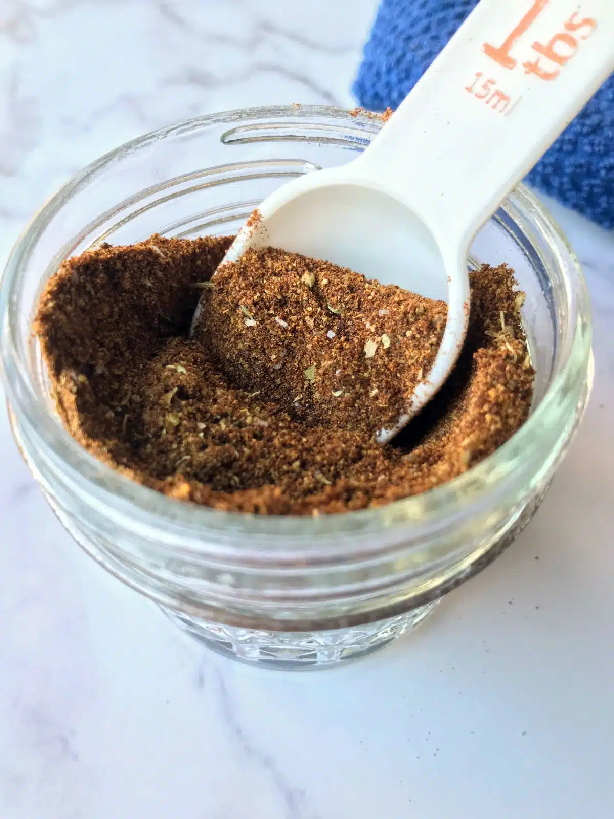 Gut-friendly seasoning in a glass jar with a measuring spoon.