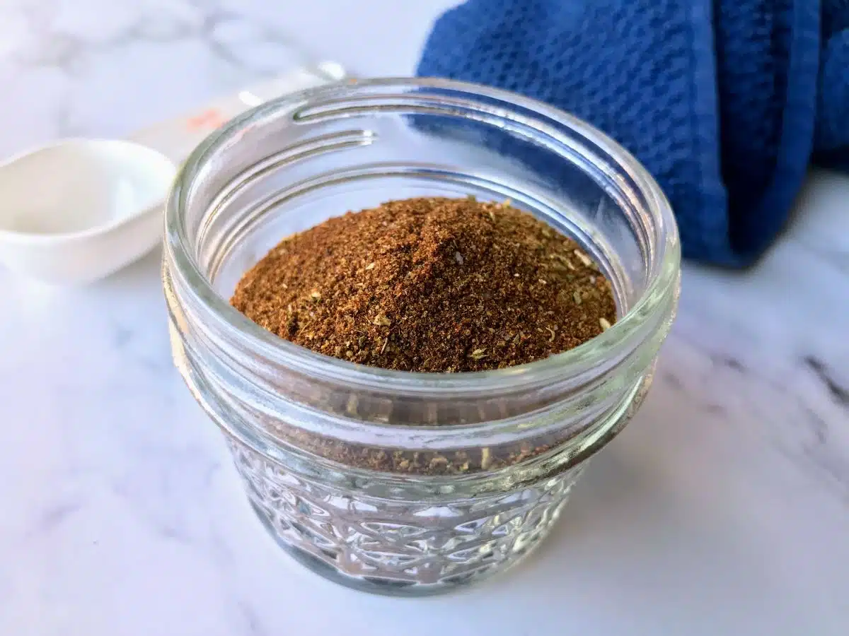 Homemade low FODMAP taco seasoning in a small glass mason jar.
