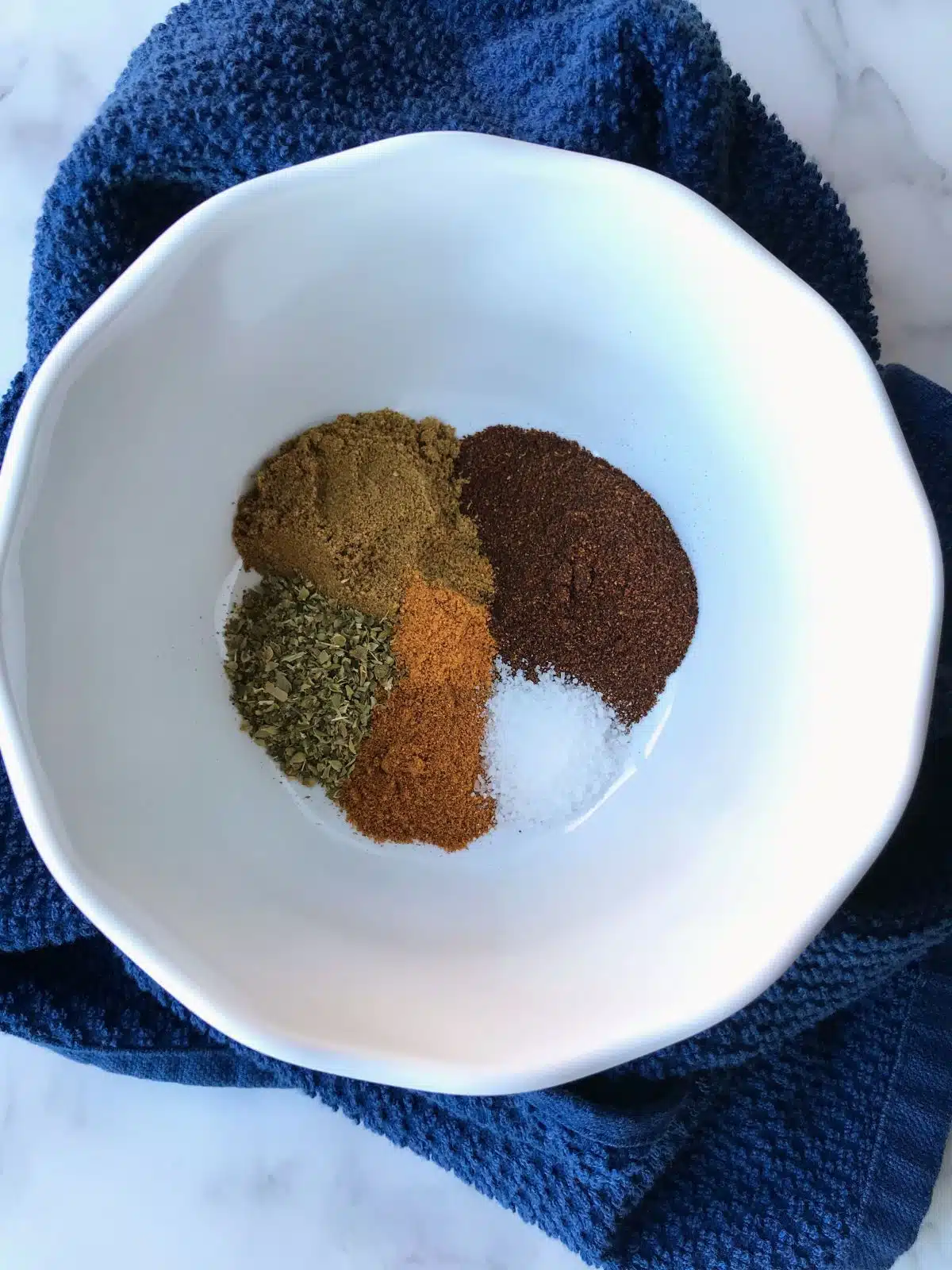 Spices for low FODMAP taco seasoning in a white bowl.