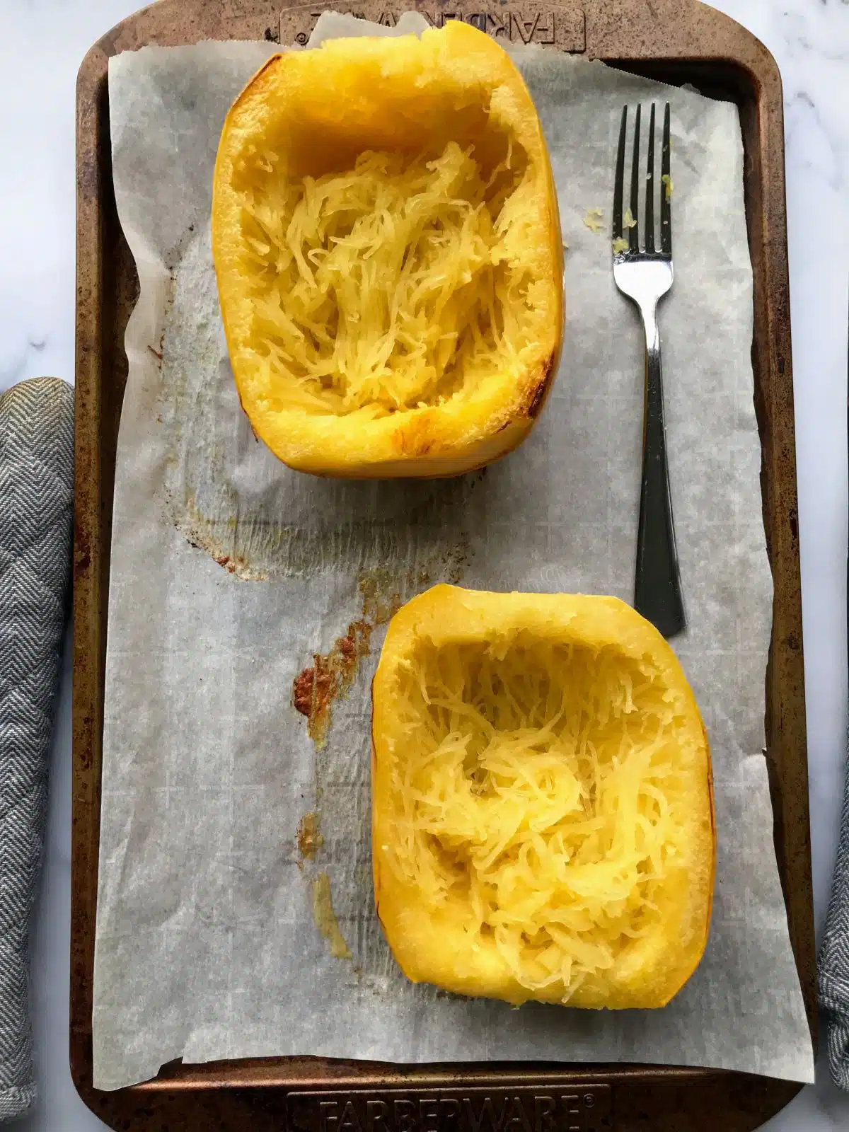 Spaghetti squash halves shredded to make strands.