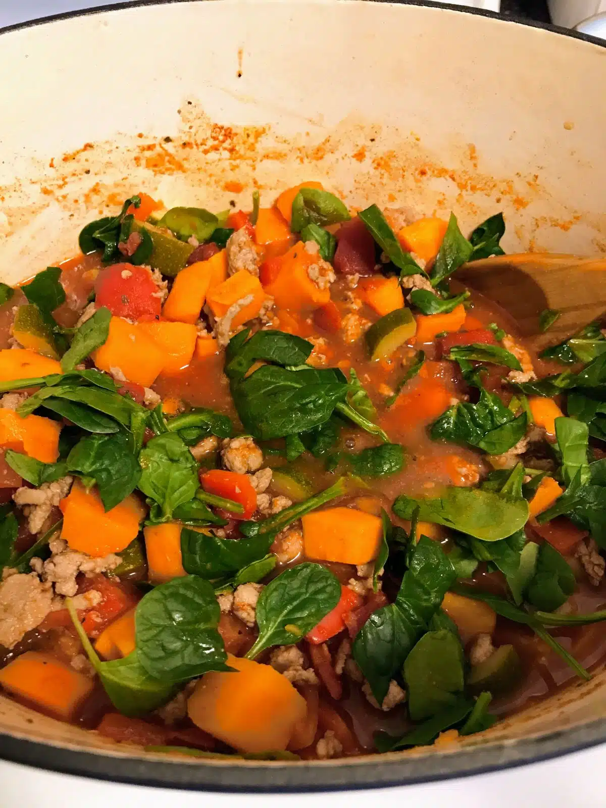 sweet potato turkey chili with spinach cooking in a pot.