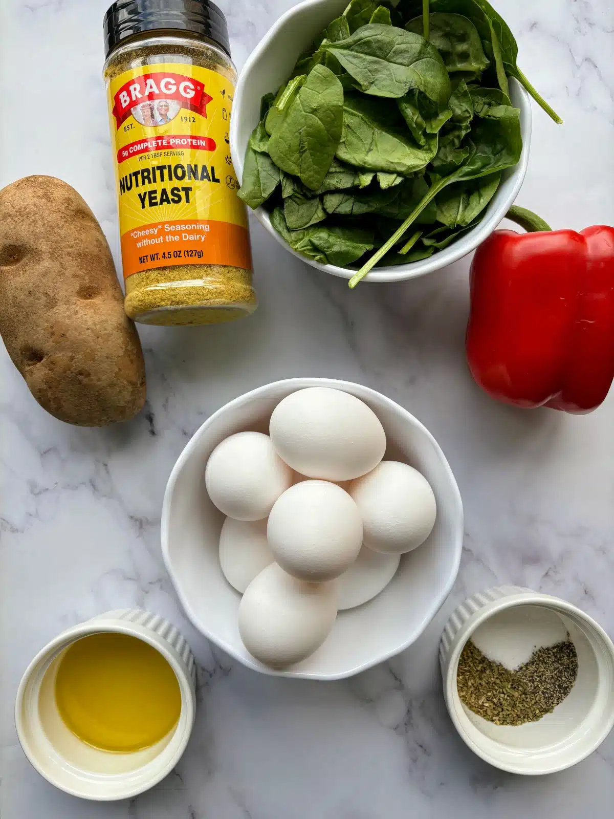 Ingredients for dairy-free frittata: potato, eggs, spinach, red bell peppers, olive oil, salt, pepper, nutritional yeast.
