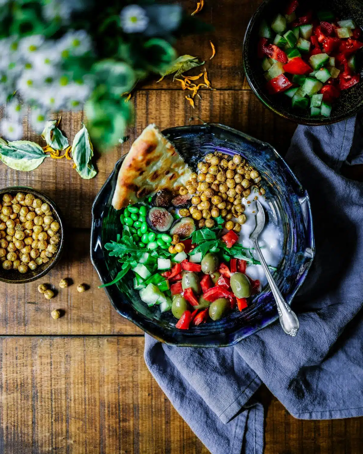 A plate with Mediterranean foods such as chickpeas, olives, and vegetables.