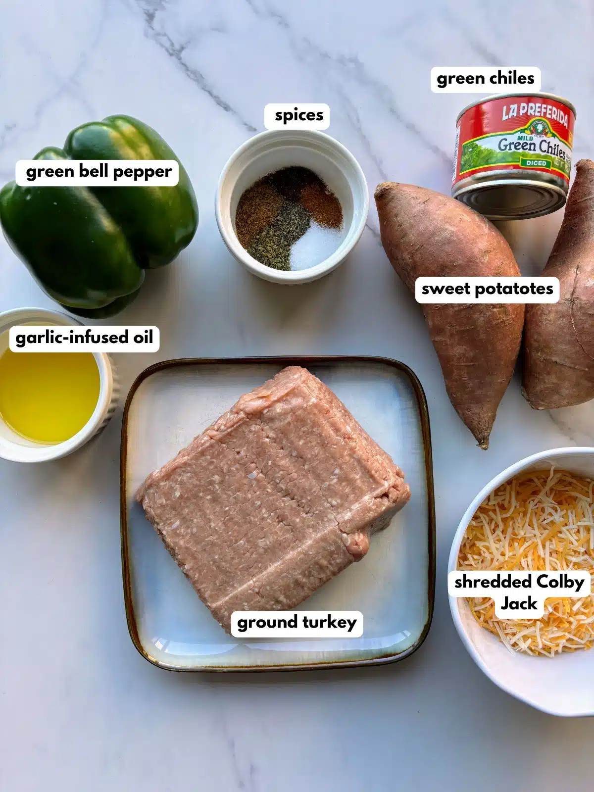 Ingredients of bell pepper, spices, sweet potatoes, canned green chiles, oil, ground turkey, and shredded cheese.
