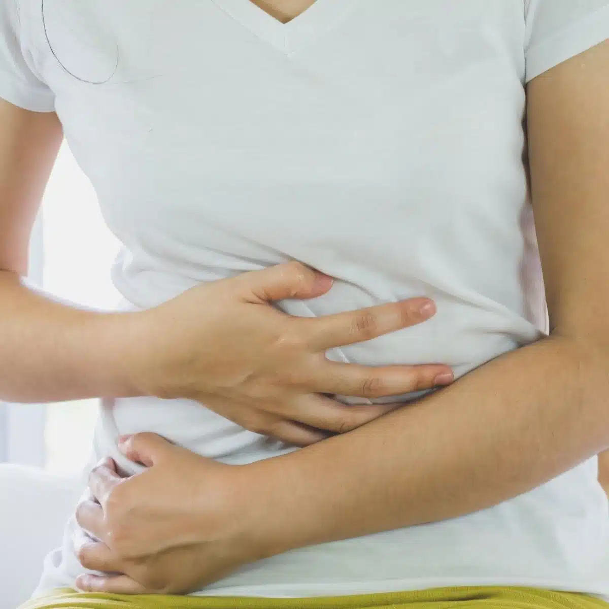Women holding her abdomen in pain.