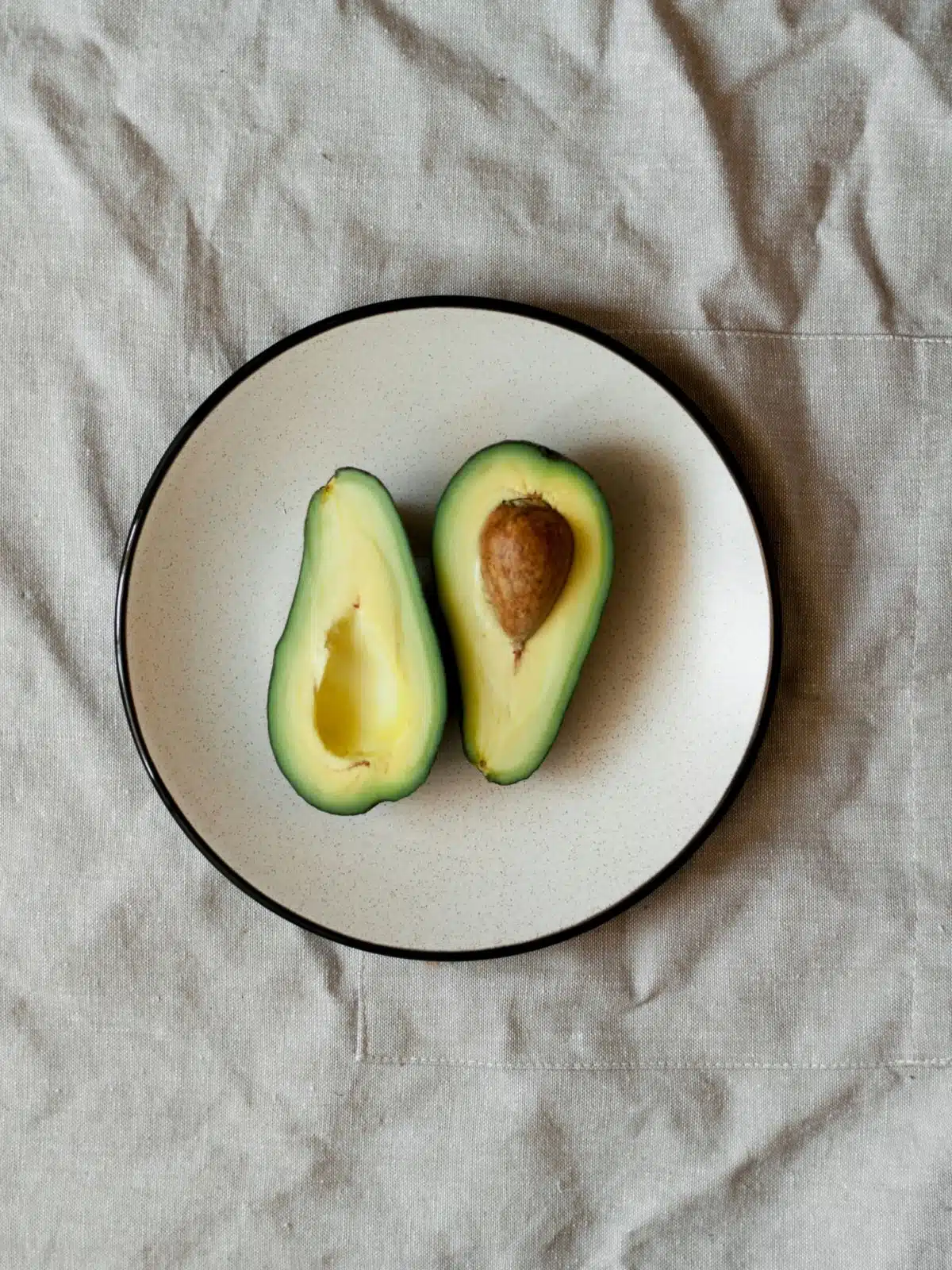avocado sliced in half on a plate.